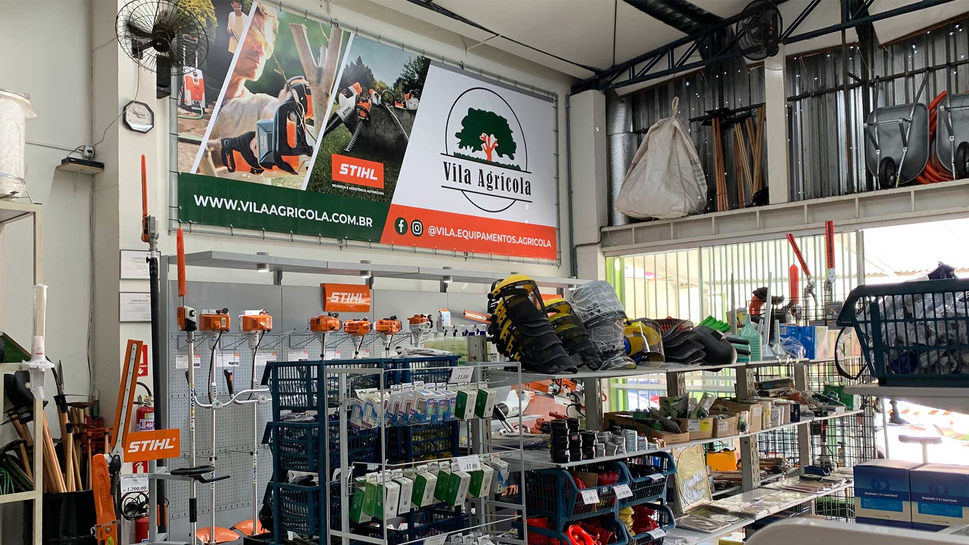Interior da loja Vila Agrícola em Itatiba, com equipamentos Stihl expostos e o banner da marca